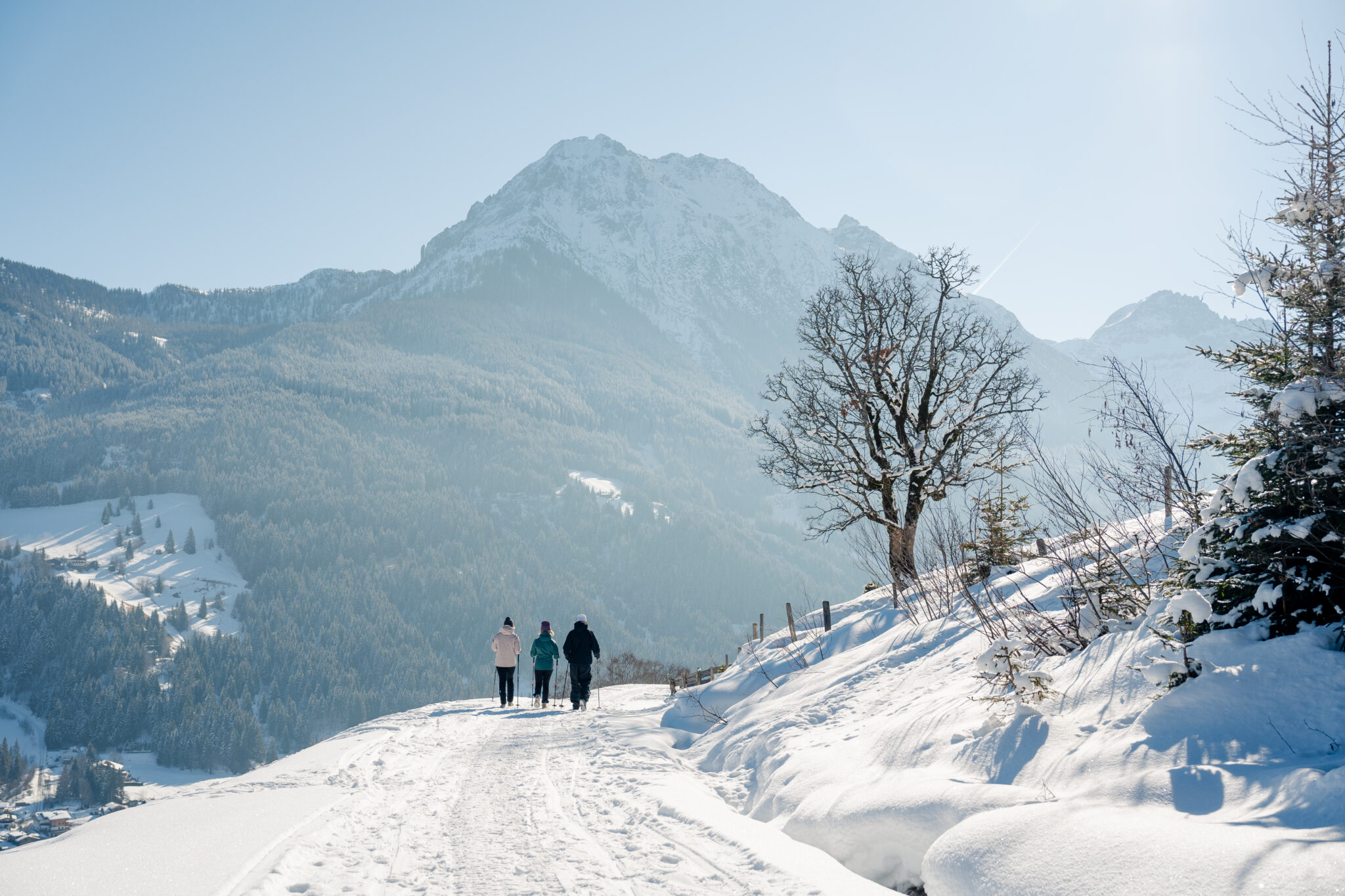 Skiurlaub Kleinarl mit Skishuttle | Hotel Angerwirt Winterwandern in Kleinarl – Ausblick auf Wagrain-Kleinarl | Hotel Angerwirt Drei Winterwanderer auf verschneitem Panoramaweg in Kleinarl mit Bergblick – Hotel Angerwirt, Wagrain-Kleinarl, Salzburger Land